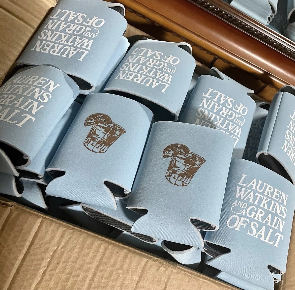 Lauren Watkins "Grain of Salt" light blue koozies with whiskey glass illustration