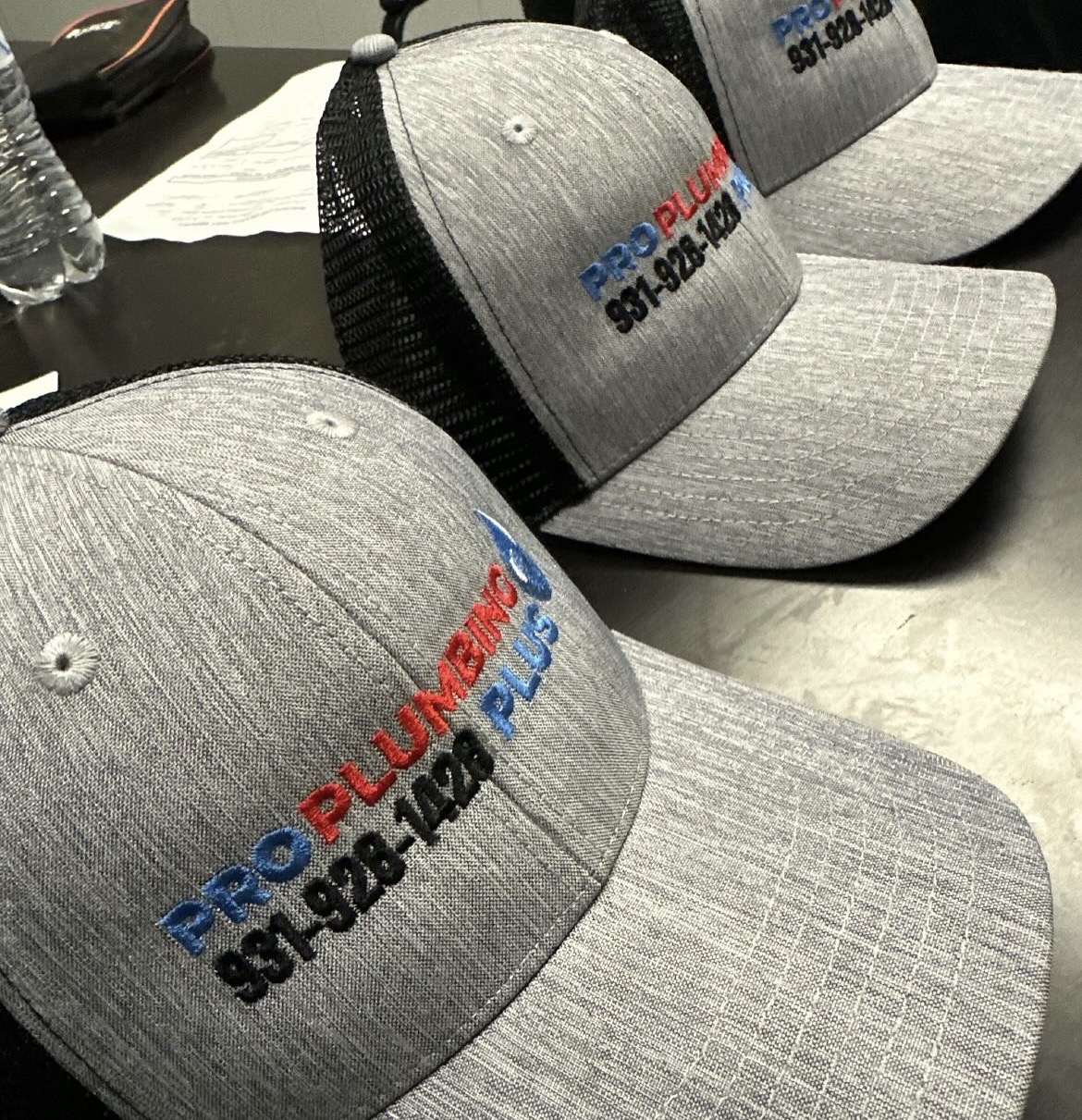 Pro Plumbing Plus embroidered gray and black trucker hats